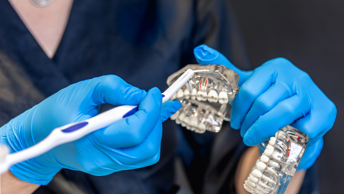 Dental professional in Costa Mesa explaining a dental implant model to a patient during an All-on-4 consultation